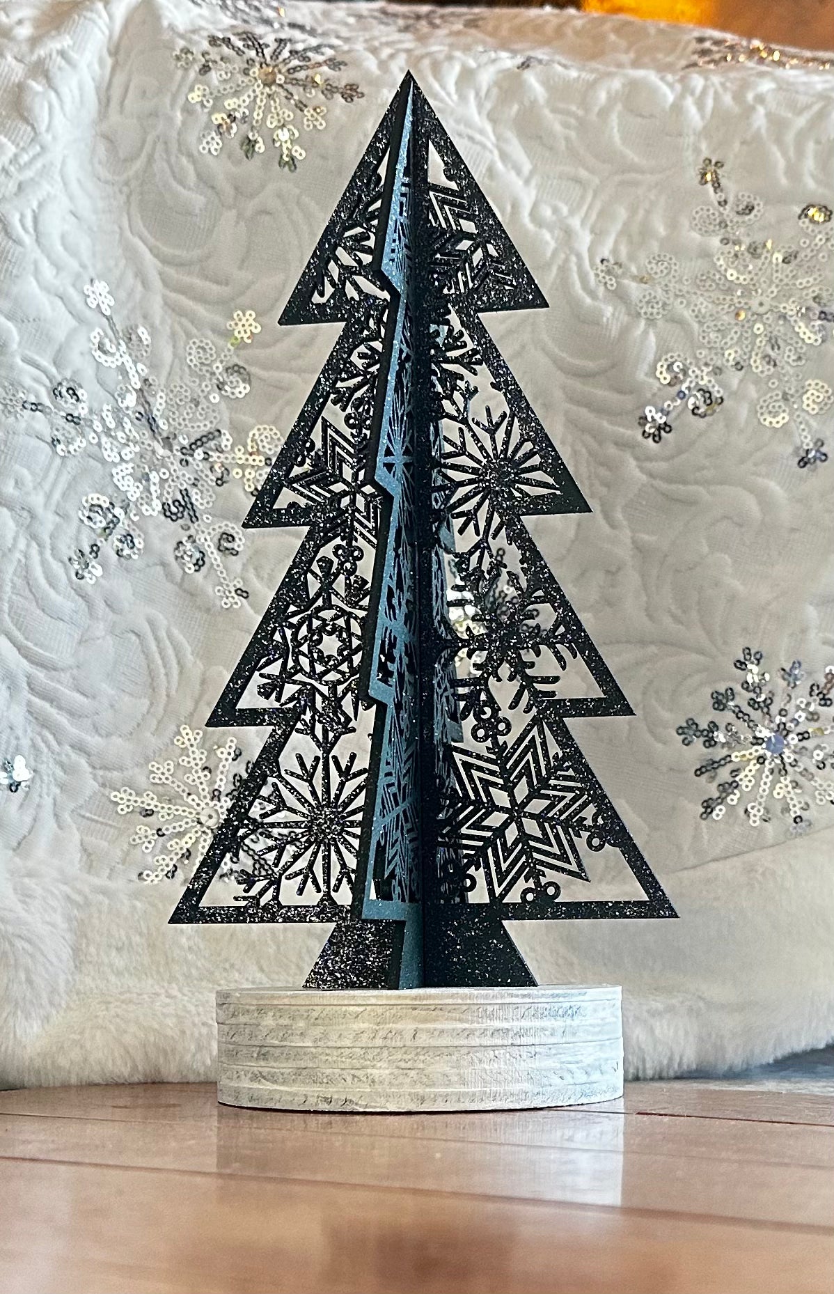 Close-up of laser cut wood Christmas tree detail — intricate cut design, natural wood holiday decor